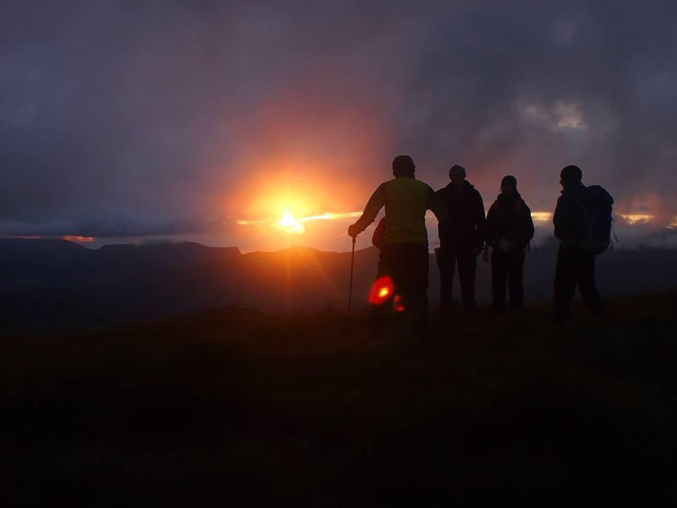 A group with a Lake District mountain guide climbing Scafell Pike at Sunset